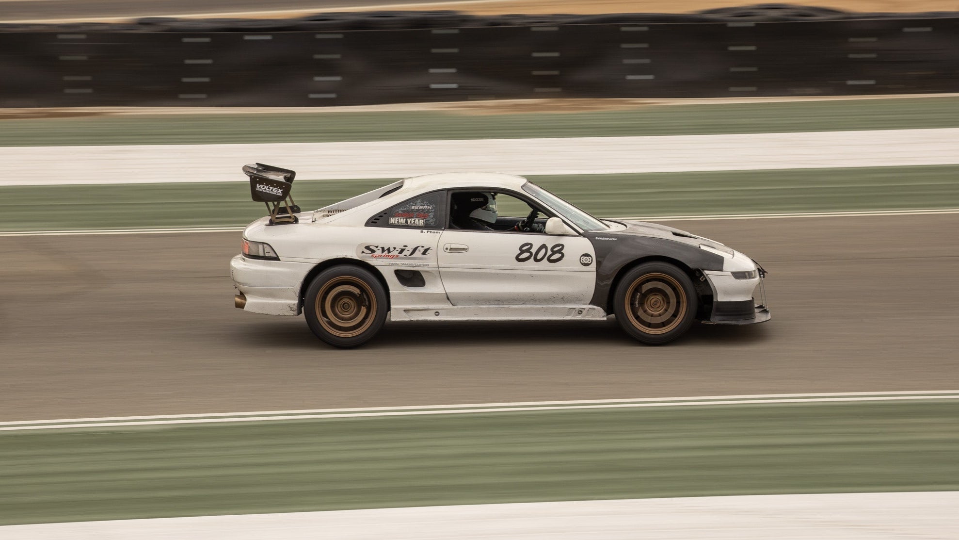 Toyota MR2 driving on the track with custom coilovers and performance parts.